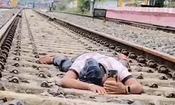 वायरल होने के लिए उल्टी टोपी लगाकर रेल पटरियों के बीच लेटा युवक