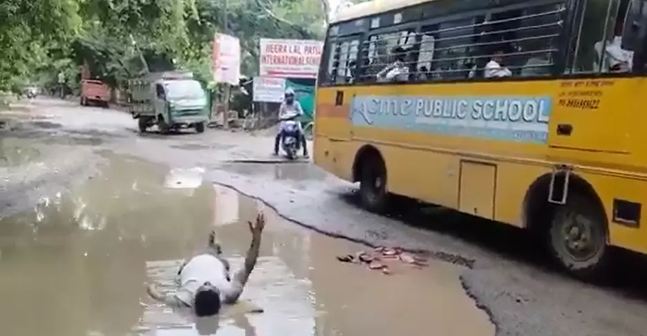गड्ढे में गिरी बेटी तो सड़कों की पोल खोलने को कीचड़ में लेटा पिता