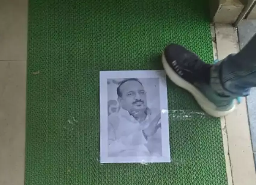 मंत्री का विरोध-डोर मेट पर चिपकाई तस्वीर-फोटो पर चढ़ाए फूल